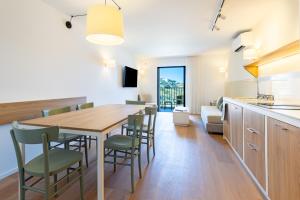 a kitchen and dining room with a wooden table and chairs at Appart'hotel Saint Francois in Calvi