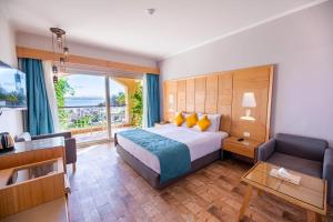 a bedroom with a bed and a couch and a window at PLM hotel Prima Life Makadi in Hurghada