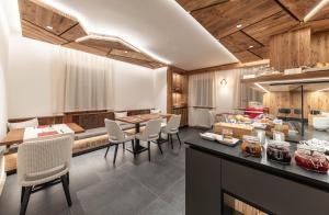 a kitchen with a counter with chairs and a table at Affittacamere Villa Sole in Fiera di Primiero