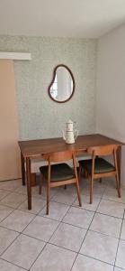 a wooden table with a mirror on the wall at Lumières de Tuffeau in Château-du-Loir