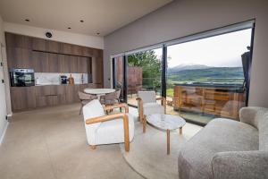 a living room filled with furniture and a large window at North Mountain View Suites in Akureyri
