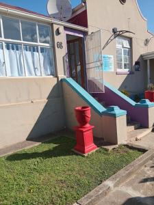 a red fire hydrant in front of a house at Feather Foot Self catering Accommodation in Heidelberg