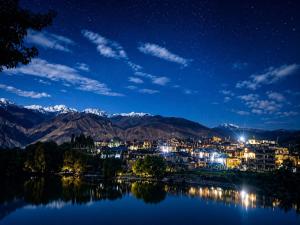a view of a city at night with mountains at Moon Lake Hotel, Nako in Nako