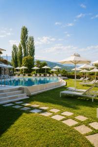 a swimming pool with umbrellas and chairs and a pool at Tilia Resort in Mouresi