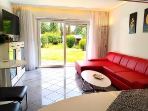a living room with a red couch and a table at Ferienhaus Ringelwiese in Schönstedt