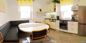 a kitchen with a table and some chairs in it at Ferienhaus Ringelwiese in Schönstedt +10 photos