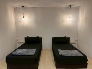 two beds in a room with lights on the wall at K-YA house in Phitsanulok +11 photos