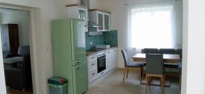 a kitchen with a green refrigerator next to a table at Fridolins Family Apartment - Ferienwohnung im Südburgenland in Markt Allhau
