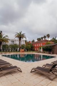 a large swimming pool with two lounge chairs next to it at Palacio São Silvestre-Boutique Hotel in Coimbra