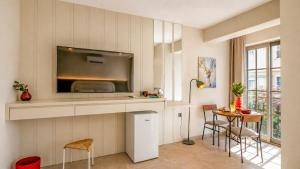 a kitchen with a tv and a table with chairs at Luz Suites in Kaş