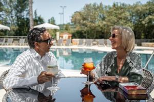 a man and woman sitting at a table with glasses of wine at Palacio São Silvestre-Boutique Hotel in Coimbra