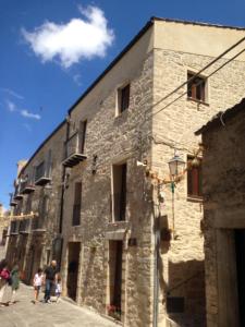 um grupo de pessoas andando em frente a um edifício em Residence Ventimiglia em Gangi