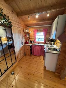 a kitchen in a log cabin with a sink at Nordlands hytta in Meby