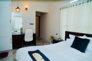 a bedroom with a bed and a desk and a chair at Hola Properties in Dhaka