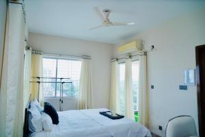 a bedroom with a bed and a large window at Hola Properties in Dhaka +1 photo