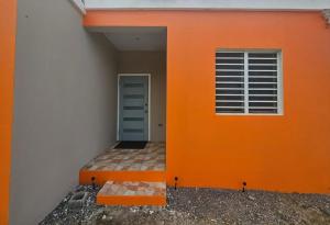 a building with an orange wall and a window at z'view apartments in Cayon