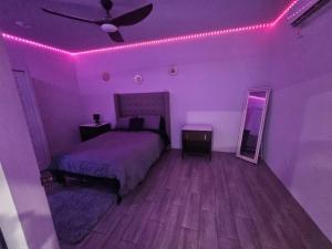 a bedroom with a bed with pink lights on it at z'view apartments in Cayon