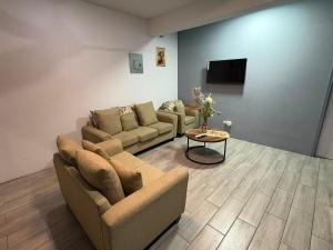 a living room with two couches and a tv at z'view apartments in Cayon