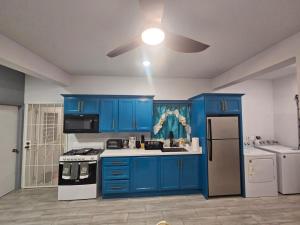 a kitchen with blue cabinets and a white refrigerator at z'view apartments in Cayon