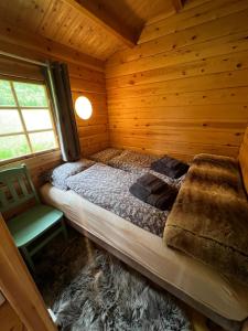 a bedroom in a log cabin with a bed and a chair at Nordlands hytta in Meby