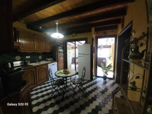 a kitchen with a table and a refrigerator at La symphonie des oiseaux in Villelongue-dʼAude