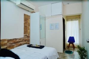 a bedroom with a bed and a blue chair at Hola Properties in Dhaka