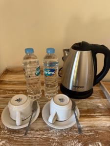 ein Teekessel und zwei Flaschen Wasser auf einem Tisch in der Unterkunft Comeon Amed in Amed