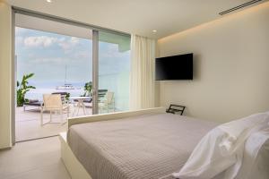 a bedroom with a bed and a view of the ocean at Kos Aktis Art Hotel in Kos