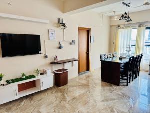 a living room with a table and a television on the wall at Hola Properties in Dhaka