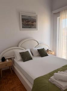 a bedroom with a large white bed with two pillows at KROKOS HOUSE in Aliveri
