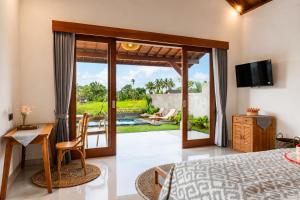 a bedroom with a bed and a view of a pool at Bagus Bandem Villa in Ubud