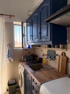 a kitchen with blue cabinets and a sink at KROKOS HOUSE in Aliveri +14 photos