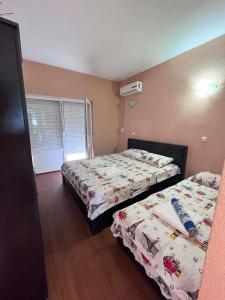 a bedroom with two beds and a window at Krapce - Lake View Apartments in Star Dojran