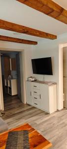a living room with a flat screen tv on a dresser at Haus Schneider in Kappel-Grafenhausen