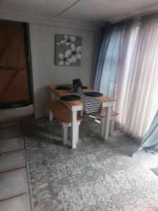 a table and bench in a room with curtains at 10 on Cane Street in East London