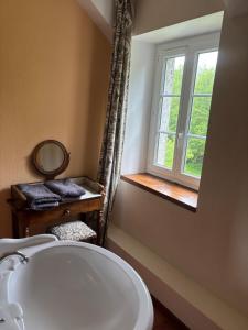 a bathroom with a white sink and a window at Gite du Moulin Vieux in Vigoulant +22 photos