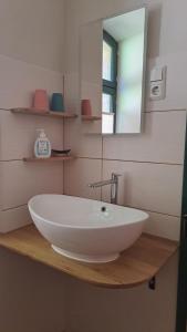 a bathroom with a white sink on a wooden counter at Oben im Selketal Parterre in Harzgerode