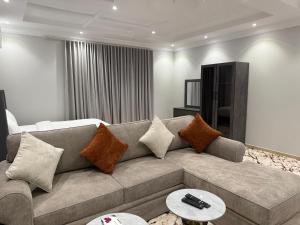a living room with a couch with pillows at شقق النخبة The Elite department in As Sayl aş Şaghīr