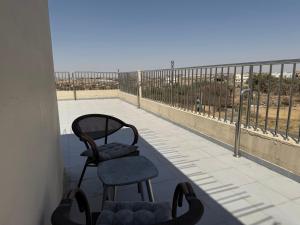 two chairs sitting on a balcony looking out at the beach at شقق النخبة The Elite department in As Sayl aş Şaghīr