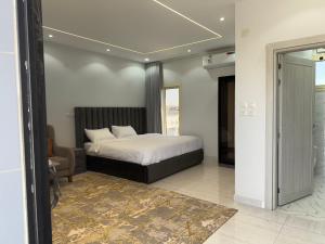 a bedroom with a bed and a chair and a window at شقق النخبة The Elite department in As Sayl aş Şaghīr