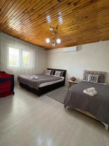 a bedroom with two beds and a wooden ceiling at HAPPY HOUSE 1 Pamukkale in Pamukkale