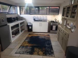 a kitchen with white cabinets and a rug on the floor at 10 on Cane Street in East London