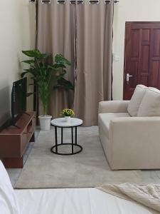 a living room with a white couch and a table at Mbeyustays in Malindi +4 photos