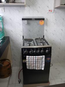 a black stove in a kitchen with towels on it at Mbeyustays in Malindi
