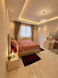 a bedroom with a bed and a table and a mirror at Resedece Ihssene in Kolea