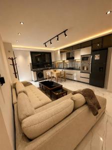 a living room with a couch and a kitchen at Resedece Ihssene in Kolea