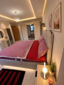 a bedroom with a large bed with a pink comforter at Resedece Ihssene in Kolea