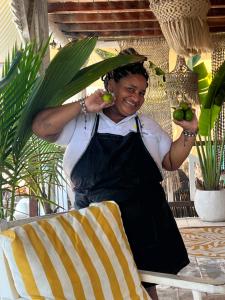a woman in an apron holding apples in a chair at Mio Mio Beach in Barú +251 photos