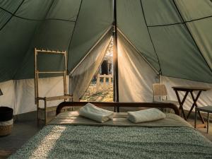a bed in a tent with two pillows on it at Montijo Garden - Glamping 25min de Lisboa in Montijo