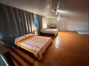 a bedroom with two beds and a window at Lodge Moorea Vaikea in Papetoai